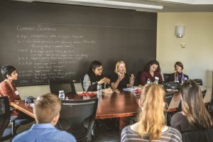 Faculty mentors (Ruth Chang, Sarah McGrath, Elizabeth Harman and L.A. Paul) sitting at a conference table discussing the pros and cons of graduate school to an audience of undergraduates. 