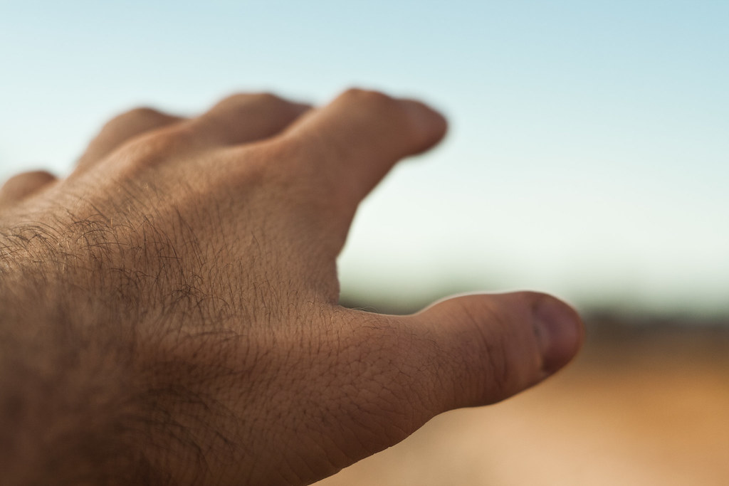 Close-up hand in front of a blurry horizon
