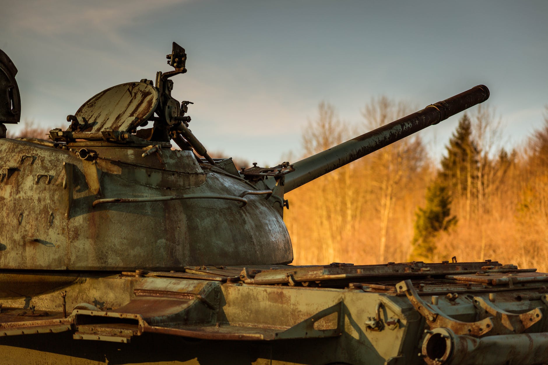 a rusty metal tank near the brown trees