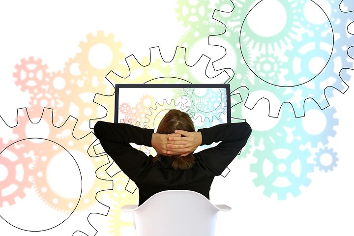 decorative image, woman at computer with rainbow gears in background