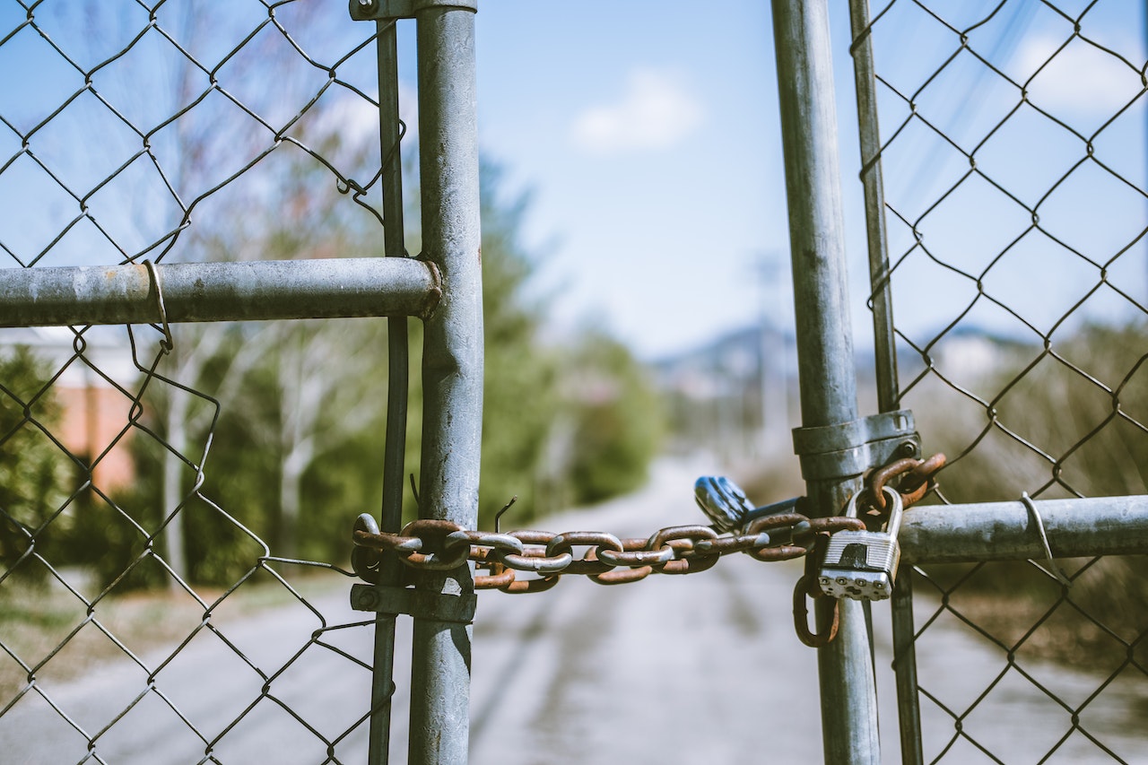 Image of chain link fence held together by locks and chain