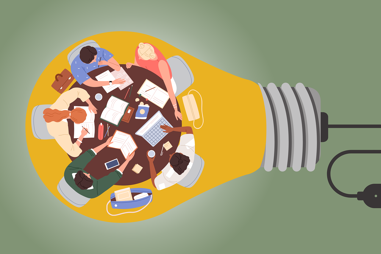 cartoon image of people working around a table inside of a light bulb