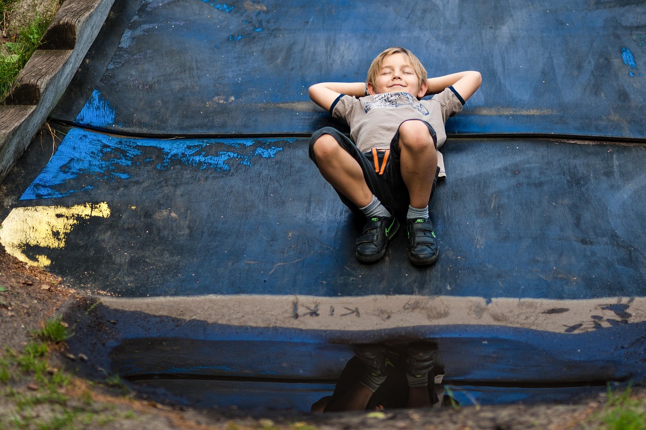 Cover Image_Lee A child laying down with their hands behind their head smiling